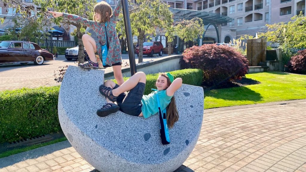 Sister and brother play in front of a hotel in Victoria BC