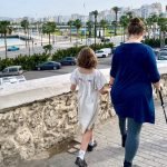 Mama and two kids walk from the medina toward the waterfront in Tangier, Morocco