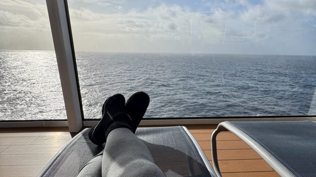 Woman with prosthetic leg relaxes in a lounge chair with an ocean view on a cruise ship - cruise lines for an introverted family